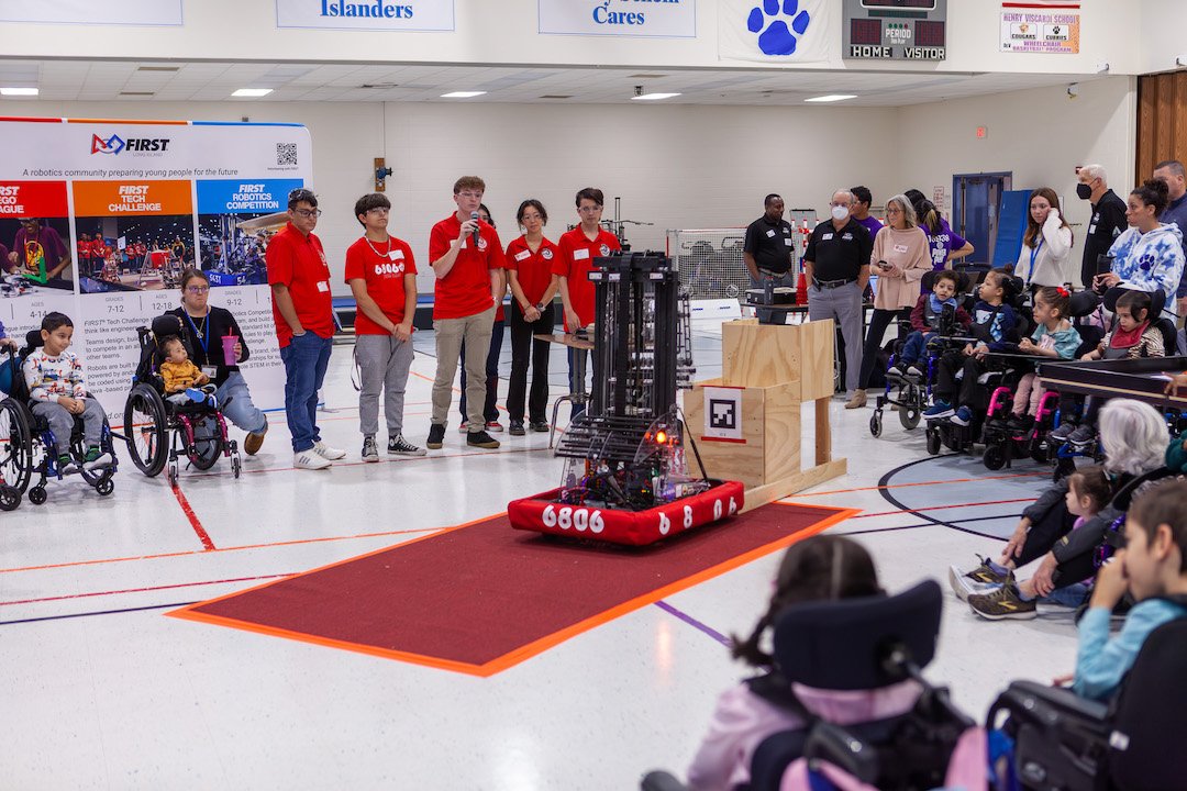 Disabled students working with a robot in the center of the room