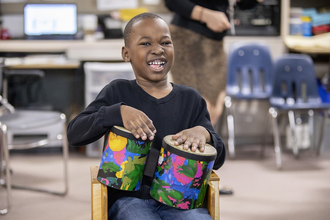 Young boy playing the drums with his hands